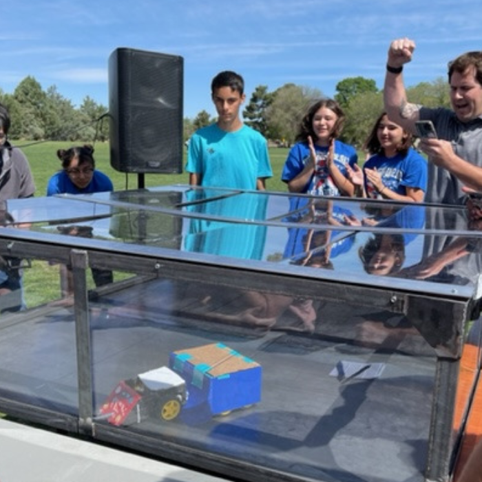 Students cheering for a robot.